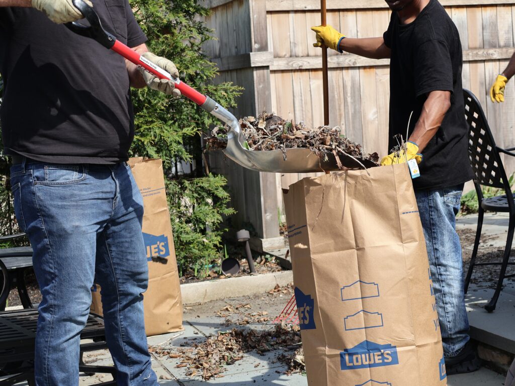 Crew putting yard debris into yard waste bag